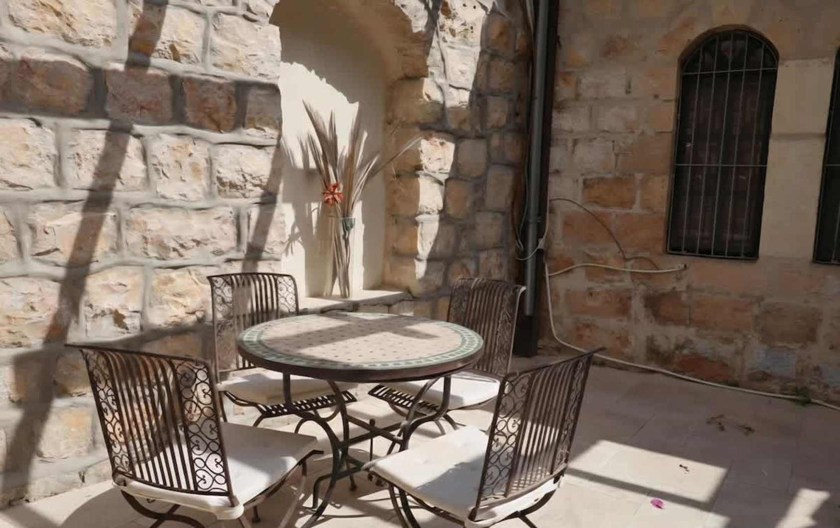 Sunlit stone courtyard of a heritage home in Nahlaot